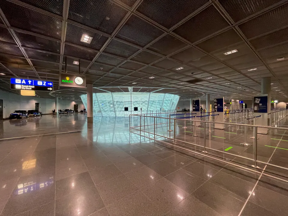 Amplio atrio y pasillo de tránsito para pasajeros en conexión en el aeropuerto internacional de Fráncfort.