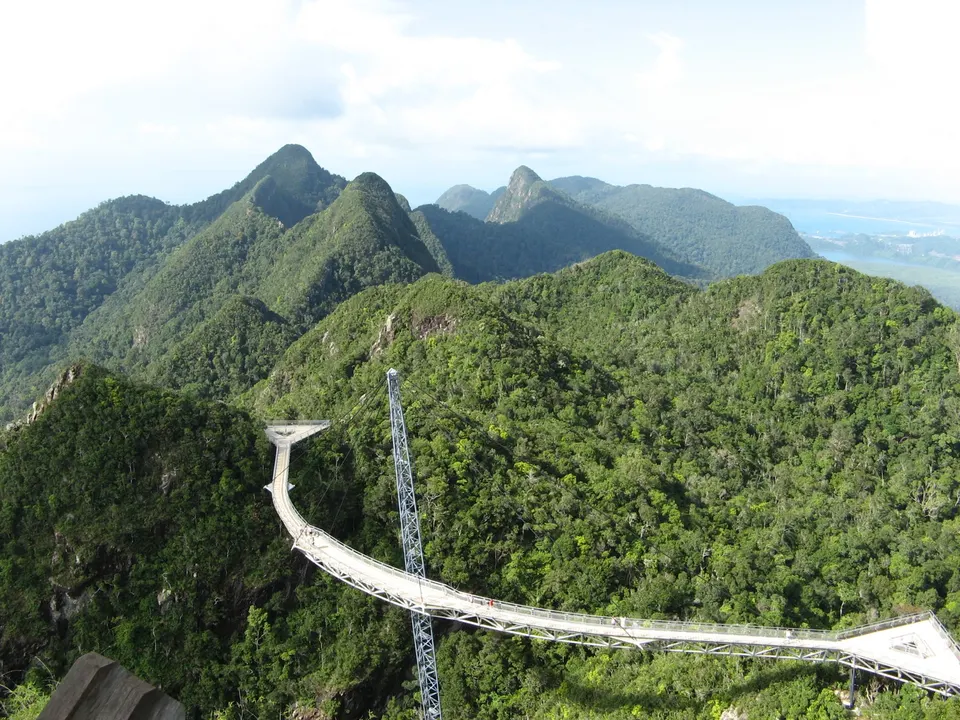 Espectacular puente curvo colgante Langkawi Sky Bridge suspendido sobre la selva tropical montañosa.