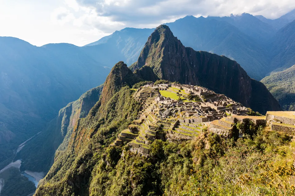 Panorámica clásica de la ciudadela inca de Machu Picchu con el Huayna Picchu elevándose sobre las nubes