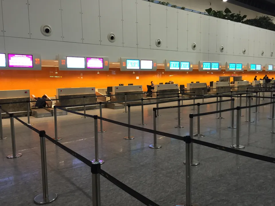 Mostradores de facturación y facturación prioritaria para pasajeros en la terminal de salidas del aeropuerto.