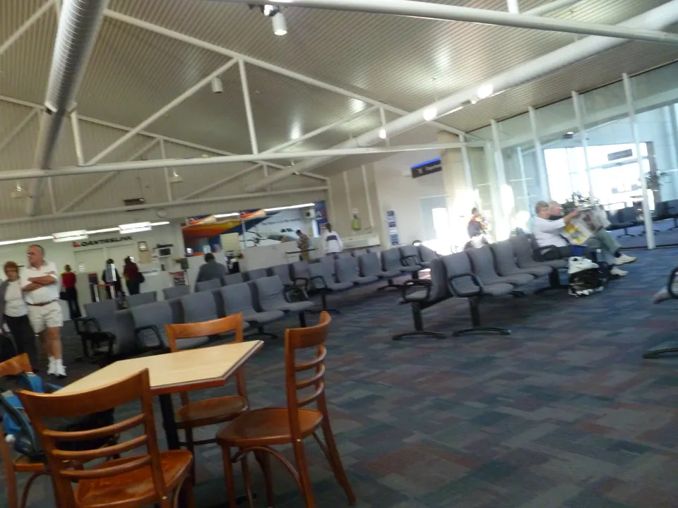 Área de asientos de la sala de espera de una puerta de embarque de aeropuerto durante un retraso de vuelo.