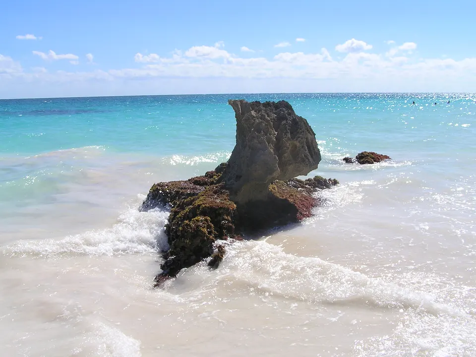 Ruinas mayas de Tulum alzándose sobre los acantilados de piedra frente al mar turquesa del Caribe.