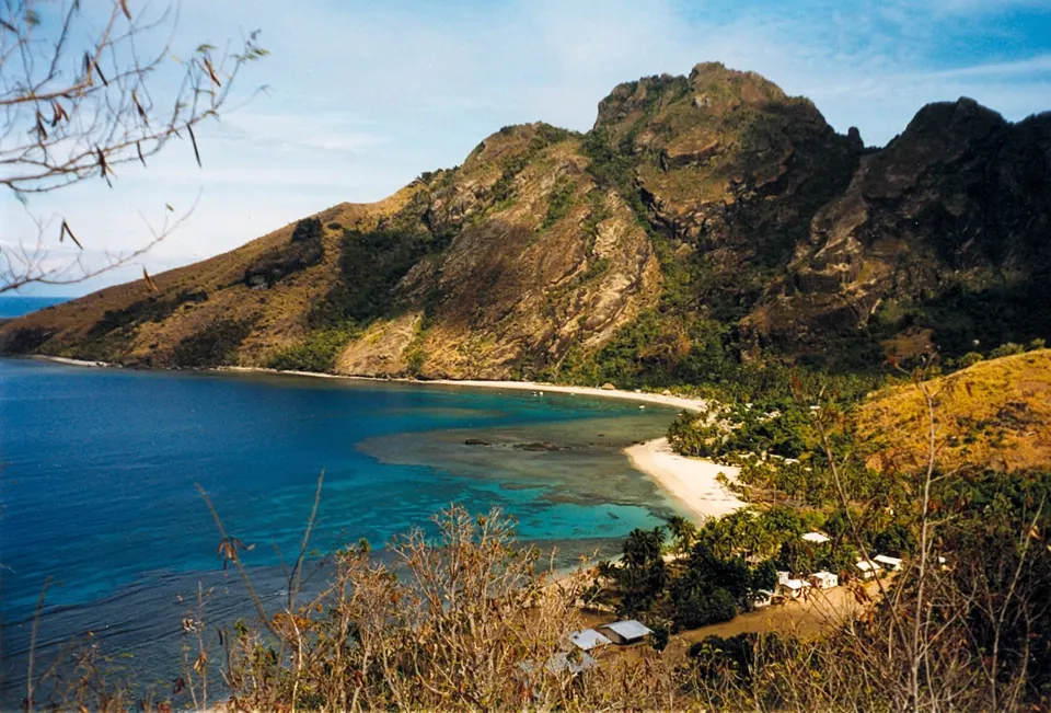 Cumbres volcánicas escarpadas y bahías de aguas azul cobalto en la isla de Waya en las Yasawa.