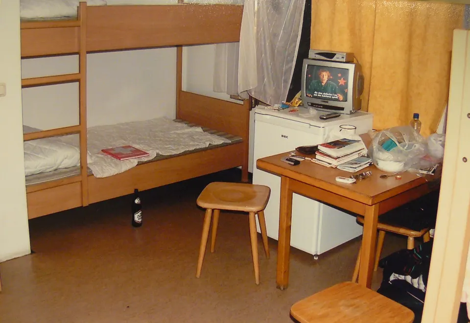 Dormitorio compartido en un albergue juvenil hostel con literas de madera.