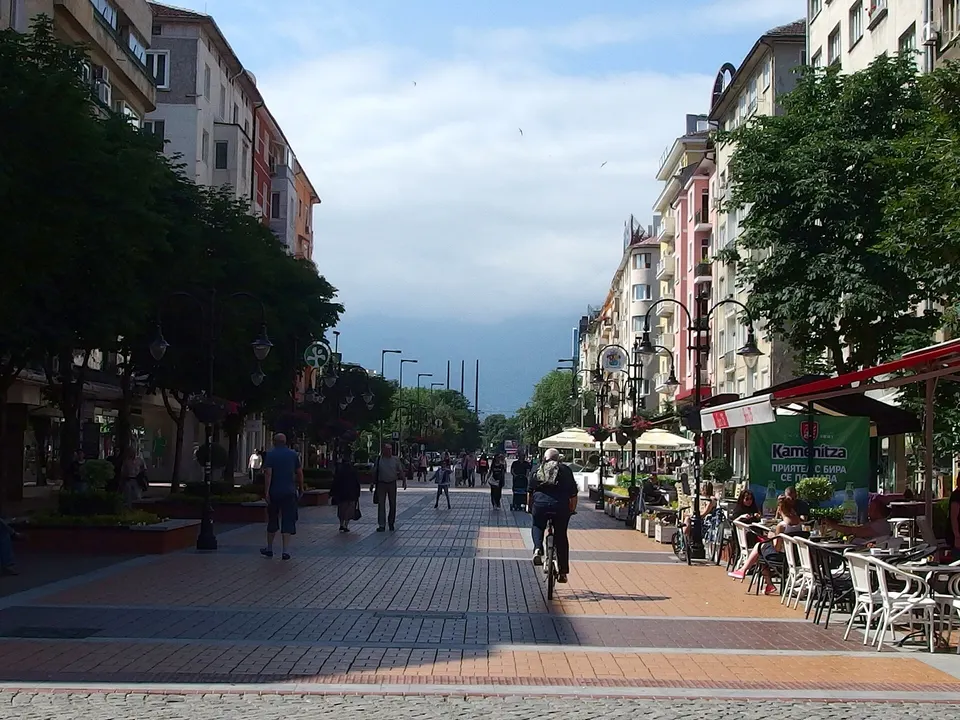 Paseo peatonal del bulevar Vitosha con cafés al aire libre y el monte Vitosha de fondo.