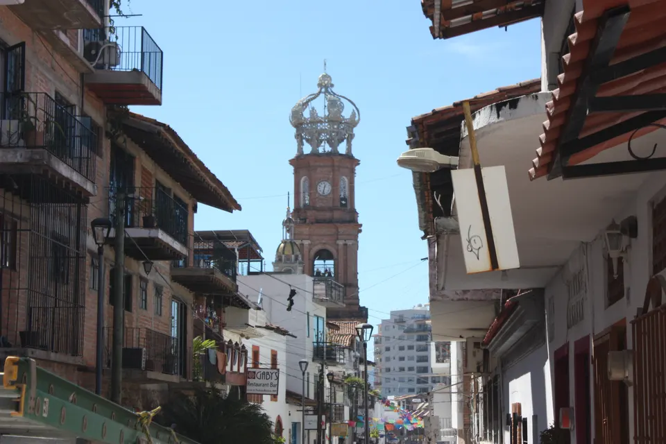 Torre de ladrillo rojo coronada por la tiara barroca de la Parroquia de Nuestra Señora de Guadalupe.