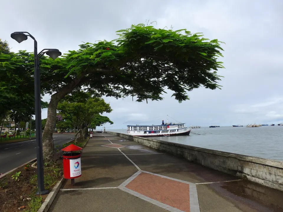 Paseo marítimo frente a la bahía de Suva con el perfil costero y las montañas verdes de fondo.