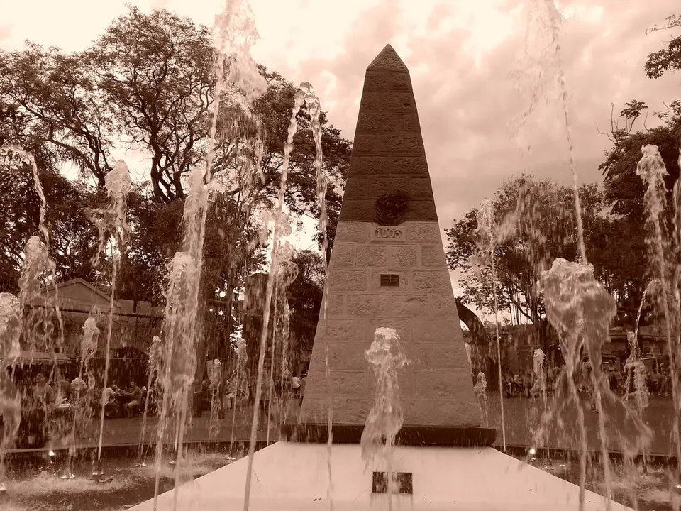 Obelisco histórico del Marco das Três Fronteiras en Foz do Iguaçu con los colores patrios frente a los ríos Paraná e Iguazú.