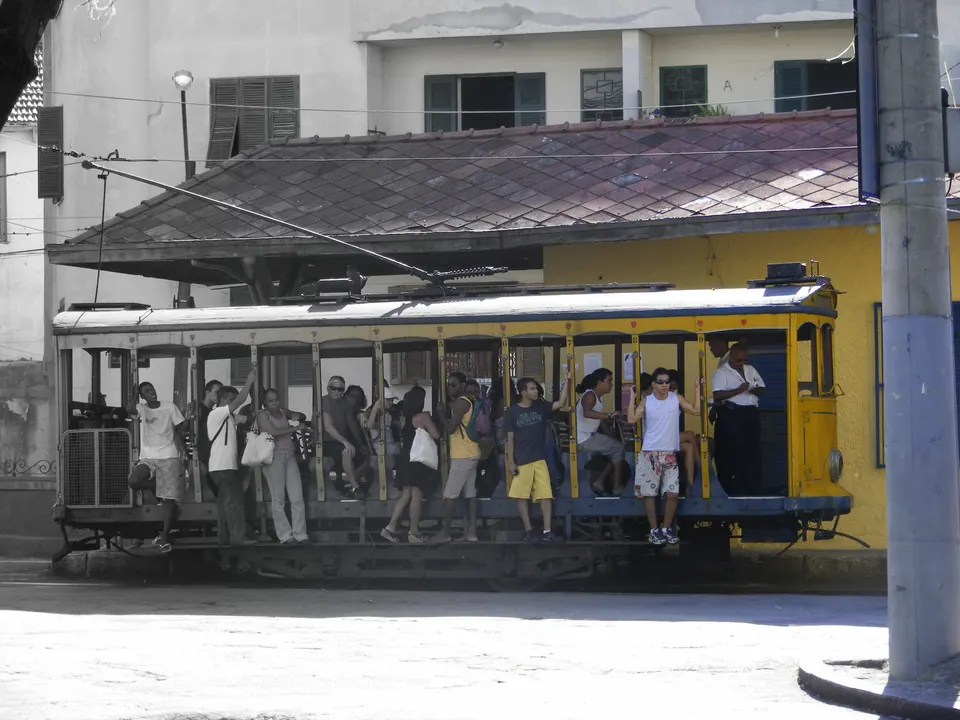 Histórico tranvía amarillo de Santa Teresa cruzando sobre los rieles y adoquines del barrio bohemio de Río de Janeiro.