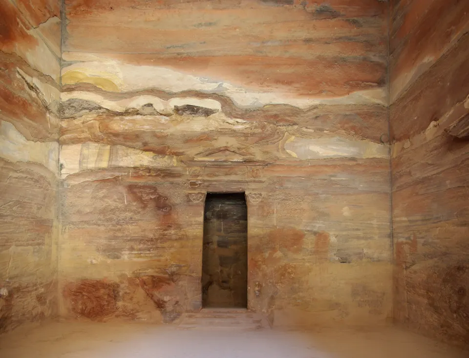 La imponente fachada helenística de El Tesoro (Al-Khazneh) tallada en la roca rosa del cañón de Petra, Jordania.