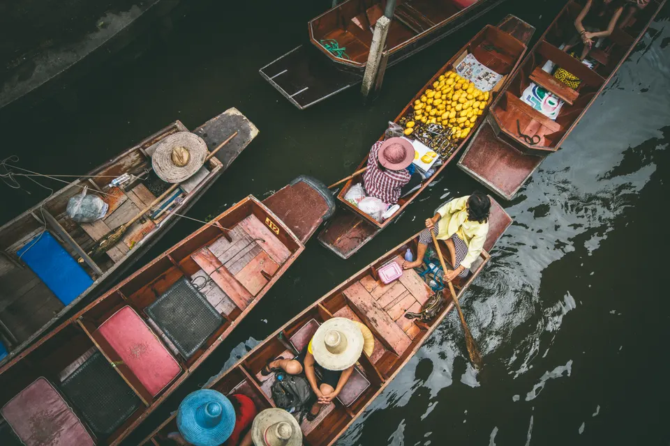 Botes de madera repletos de frutas y comidas típicas en el mercado flotante de Damnoen Saduak.