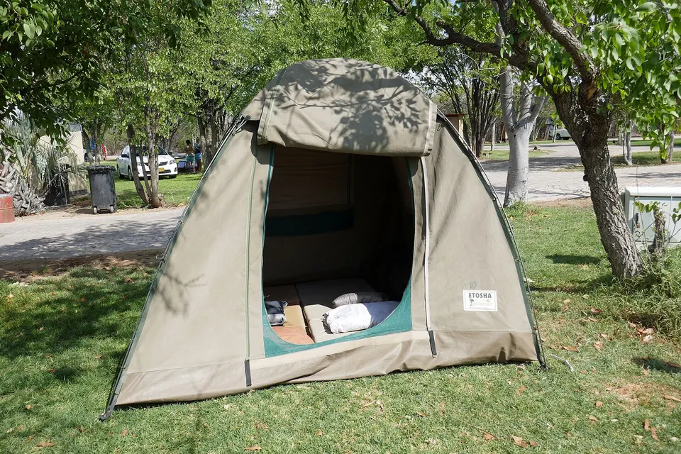 Campamento tradicional de safari con tiendas de lona bajo las estrellas en el corazón de la sabana.