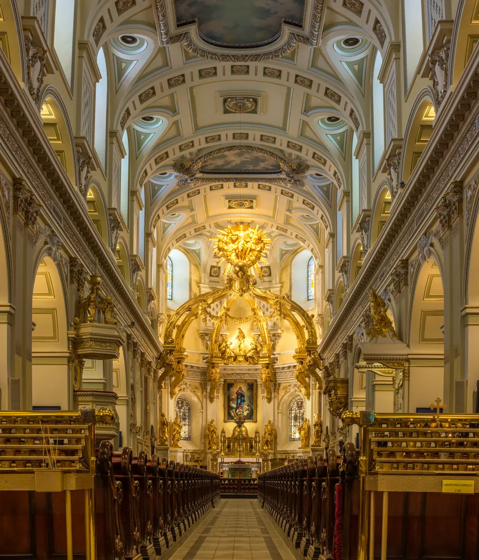 Solemne nave interior con altar mayor dorado y doseles esculpidos en la Basílica-Catedral Notre-Dame de Québec.