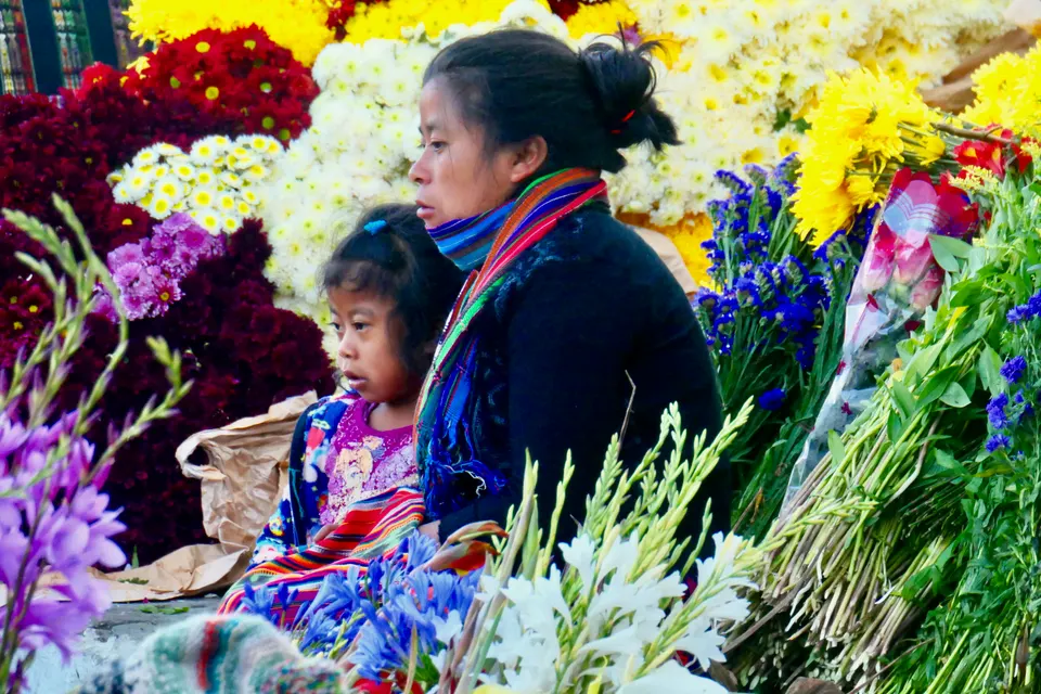 Puestos de artesanías textiles multicolores y huipiles en el mercado tradicional de Chichicastenango.