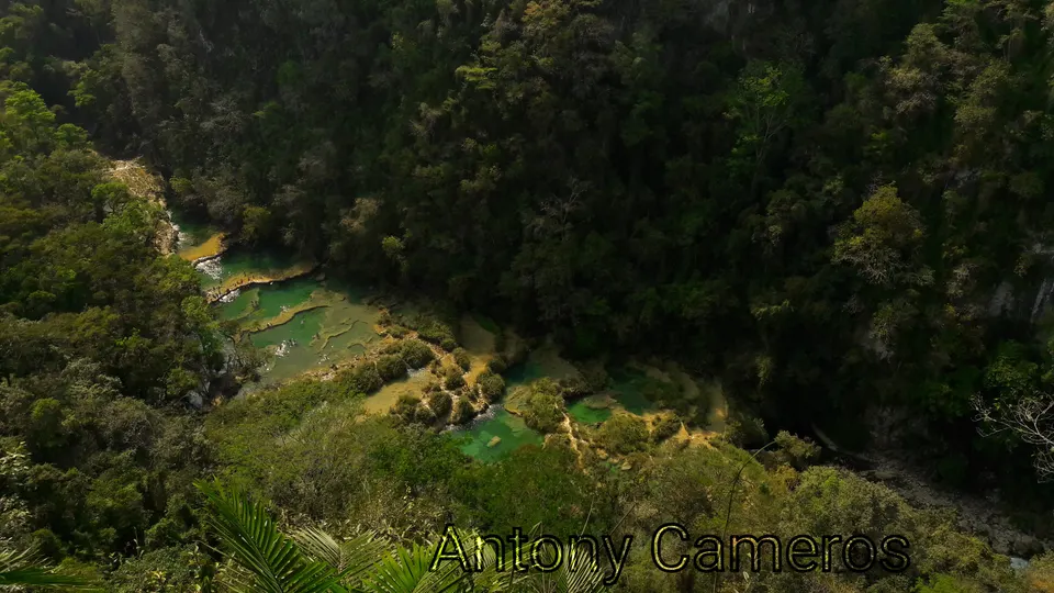Vista aérea panorámica desde El Mirador mostrando el puente natural de roca caliza y las pozas de Semuc Champey.