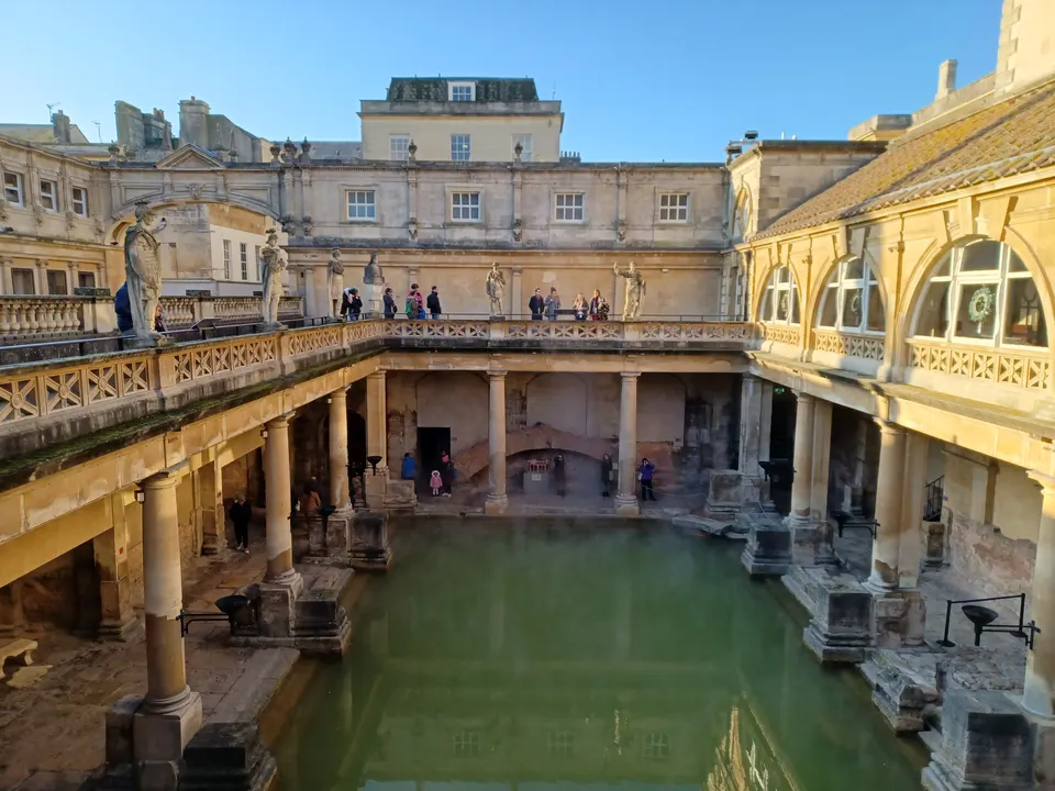El Great Bath de las Termas Romanas de Bath con agua termal y estatuas romanas.