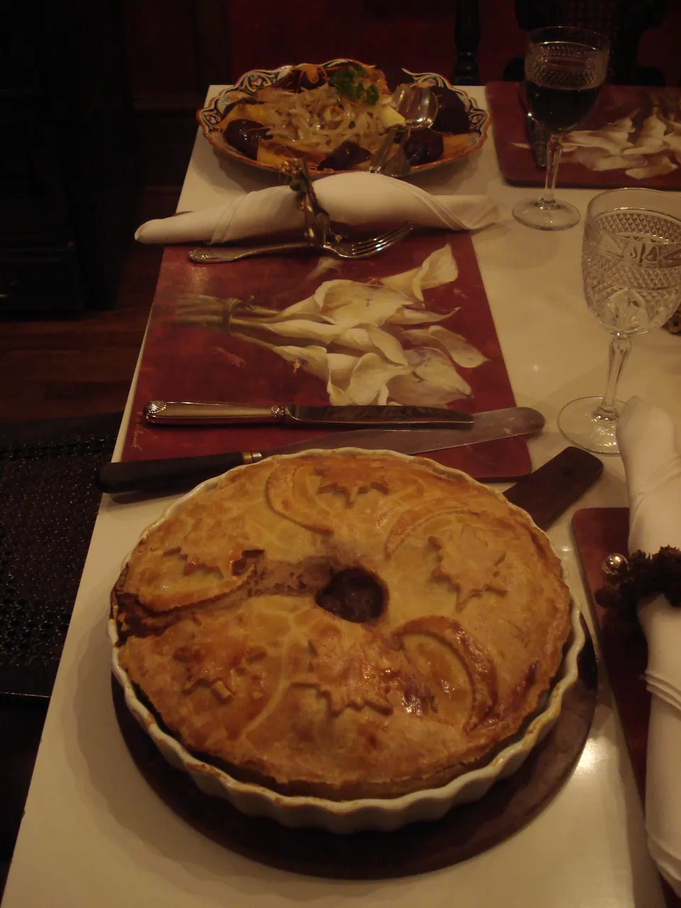 Tradicional tourtière quebequense, pastel de carne especiada horneada en costra de masa dorada servida en la mesa.