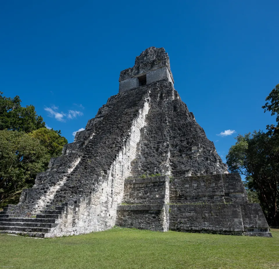 Vista de las pirámides y templos mayas milenarios de Tikal emergiendo entre la densa selva tropical del Petén.