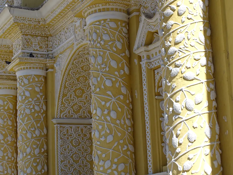 Detalle de la elaborada fachada barroca amarilla con filigranas de estuco blanco de la Iglesia de La Merced.