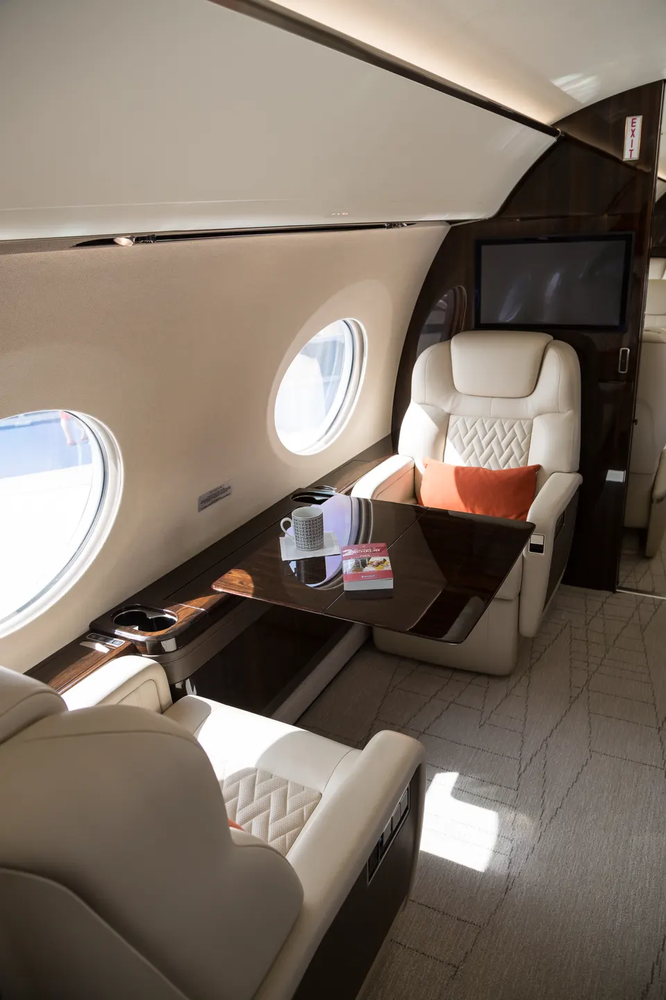 Interior iluminado de la cabina de un avión con filas de asientos de pasajeros.