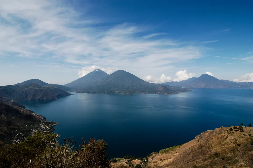 Panorámica de las aguas azules del Lago de Atitlán rodeado por los volcanes San Pedro, Tolimán y Atitlán.
