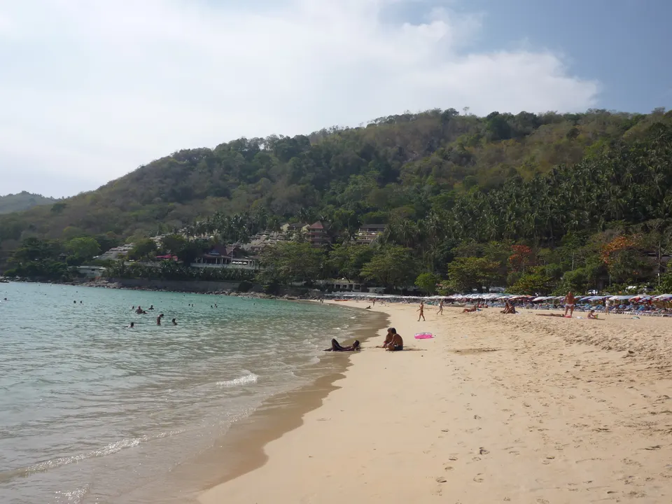Bahía protegida de aguas tranquilas y vegetación tropical en la playa de Nai Harn, Phuket.