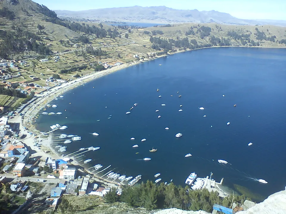 Embarcaciones turísticas y orilla lacustre en la playa de Copacabana a orillas del Titicaca.