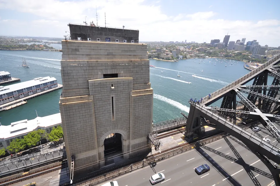 Estructura monumental de acero del Sydney Harbour Bridge cruzando las aguas de la bahía.