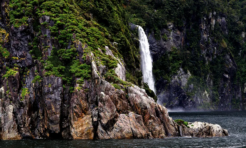 La colosal catarata de Lady Bowen Falls precipitándose con estruendo sobre las aguas del fiordo.