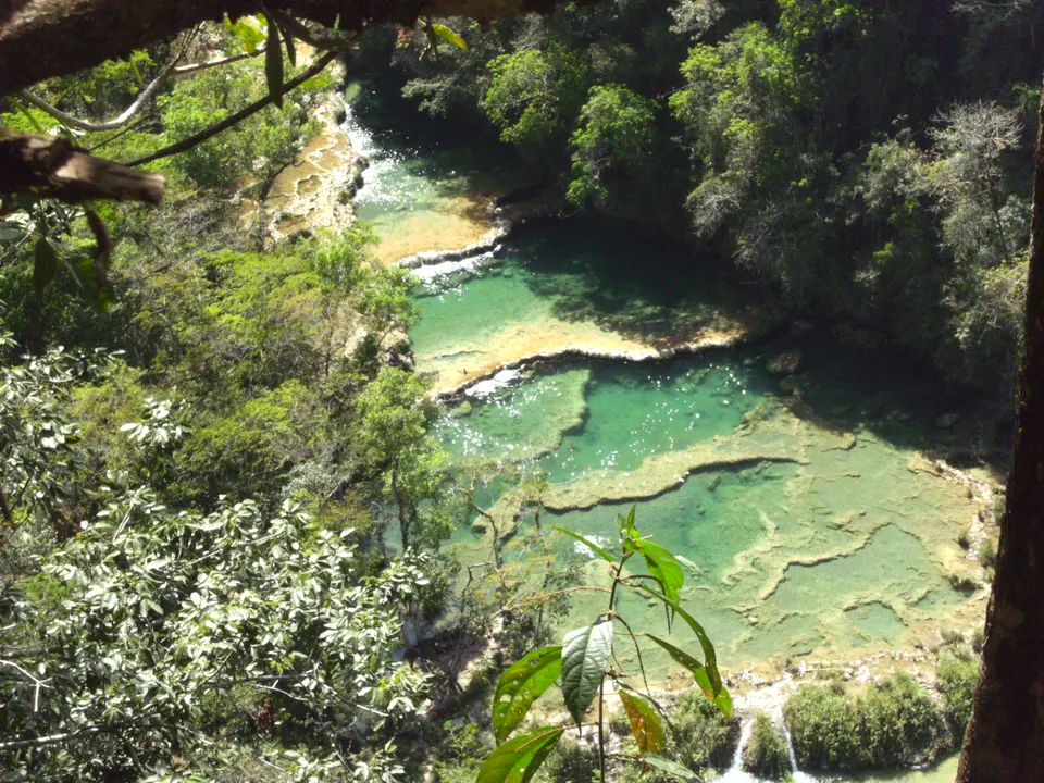 Cascada cristalina en el Río Lanquín rodeada de vegetación selvática virgen.