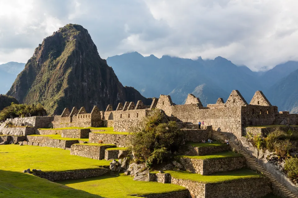 Vista clásica de la ciudadela inca de Machu Picchu con sus andenes y el pico Huayna Picchu entre la niebla