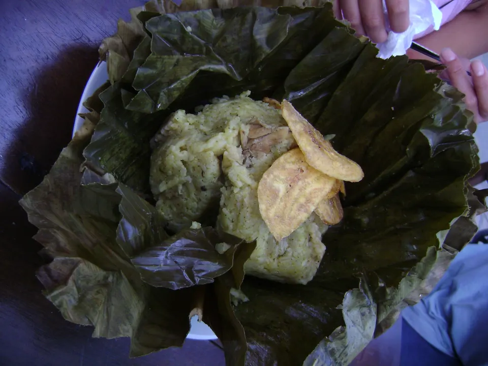Tradicional juane de arroz y gallina envuelto en hoja de bijao servido junto a porciones de tacacho con cecina ahumada