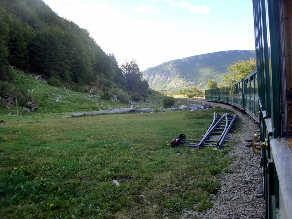 El Tren del Fin del Mundo con locomotora a vapor avanzando a través del bosque de lengas en el valle del río Pipo.
