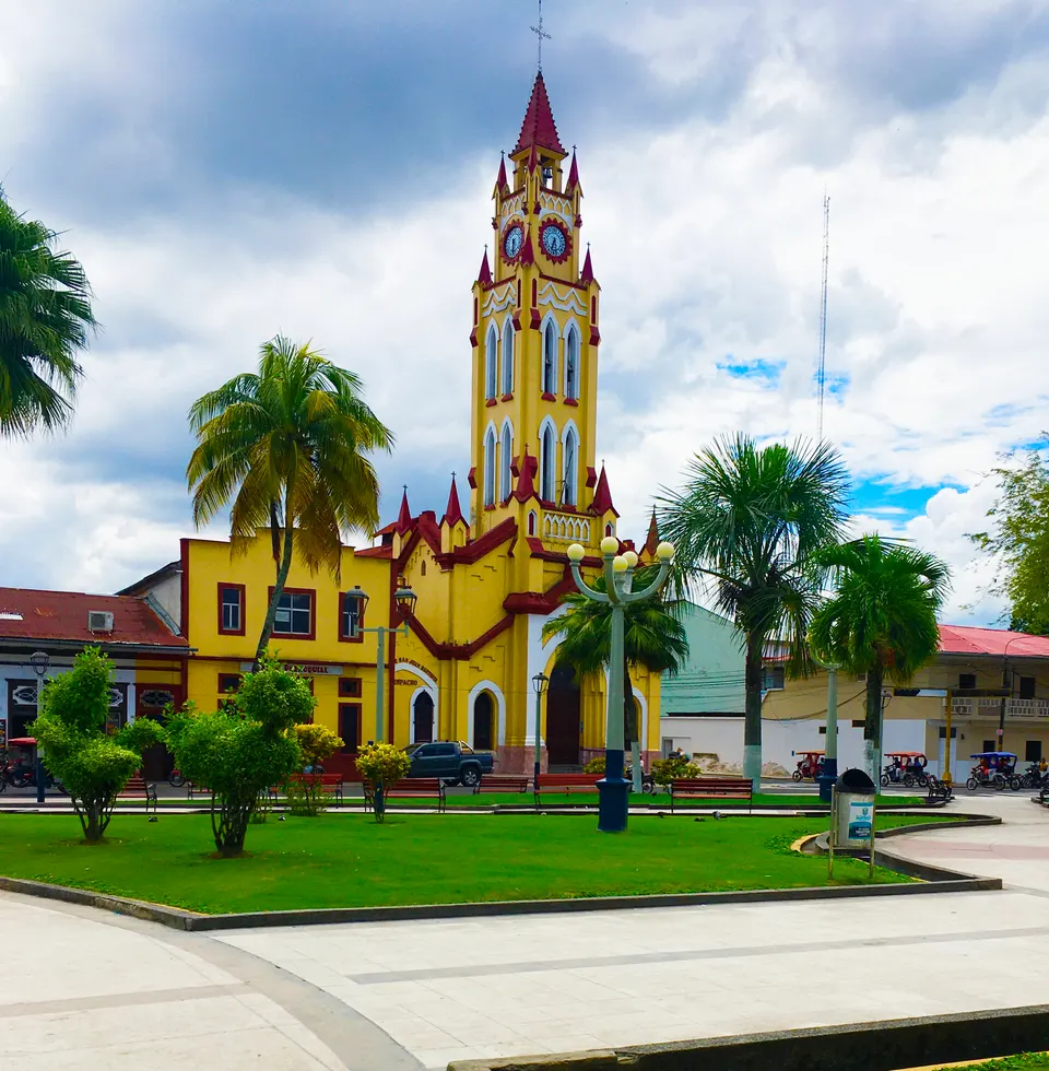 Torre neogótica de la Iglesia Matriz de Iquitos y jardines tropicales en la Plaza de Armas