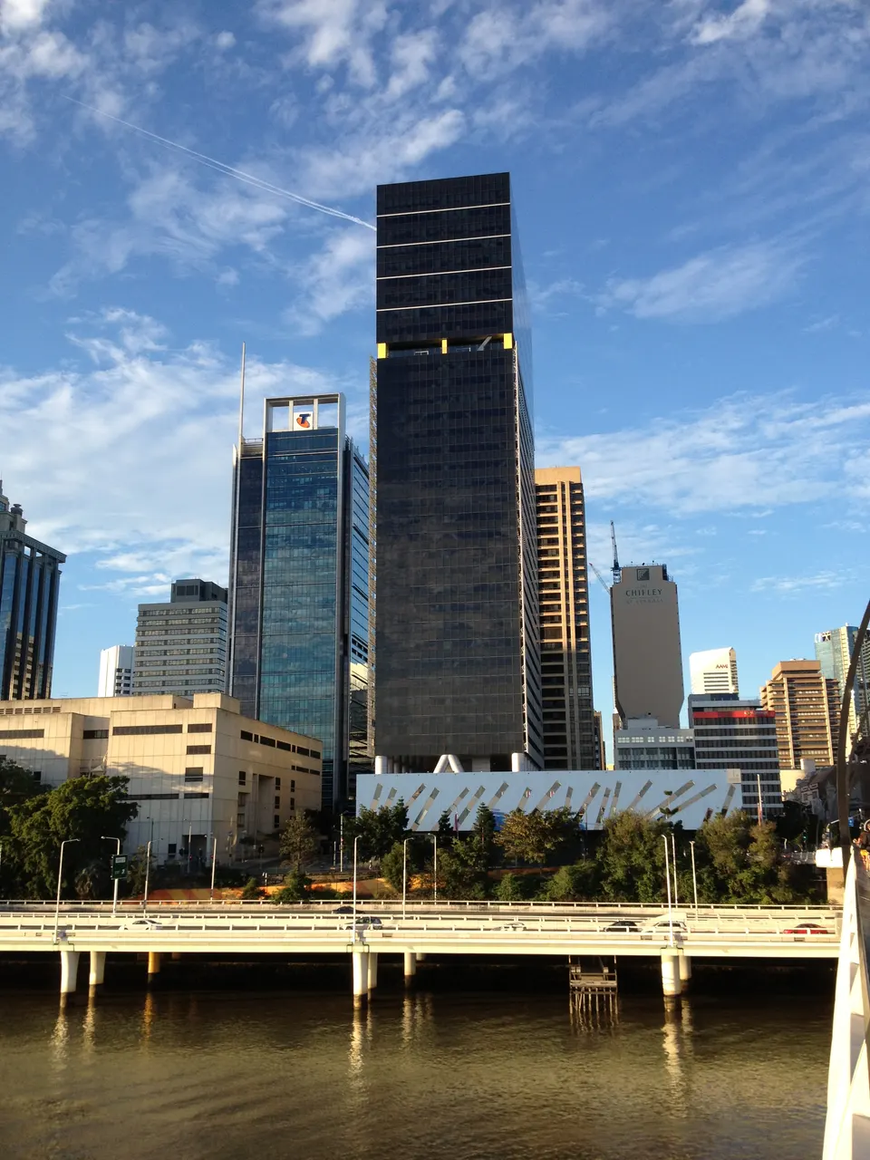 Rascacielos iluminados del distrito financiero de Brisbane reflejados sobre las curvas del río.